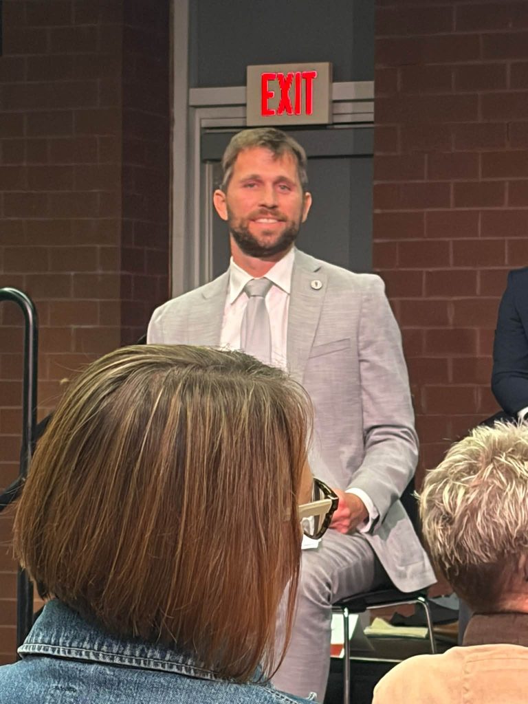 Ross Evans in a grey suit standing to answer a question at the County Council candidate forum at Salisbury University.
