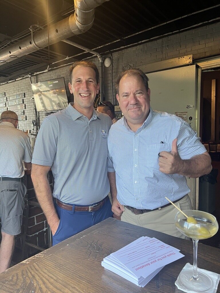 Ross Evans standing with an attendee at the Evolution Brewing fundraiser.